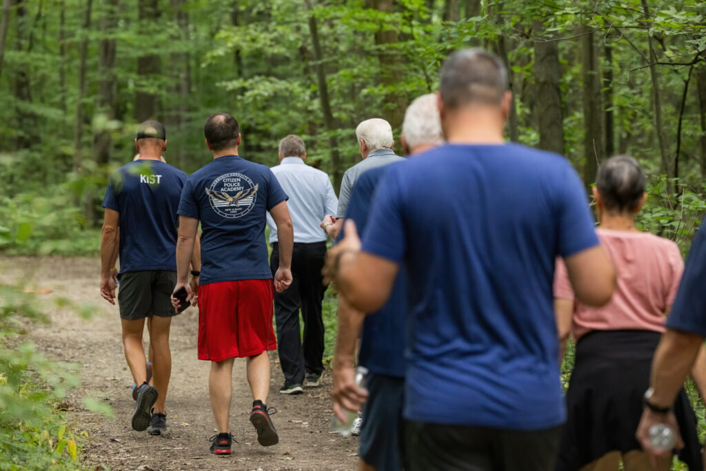 group of people walking along a wooded path