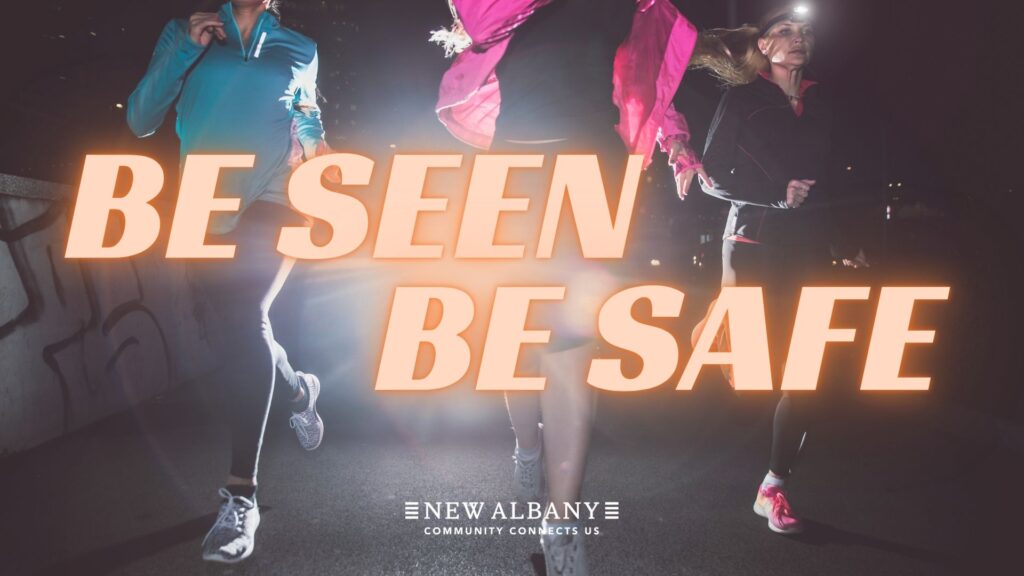 Three people running at night with the text "Be Seen Be Safe" in bold letters.