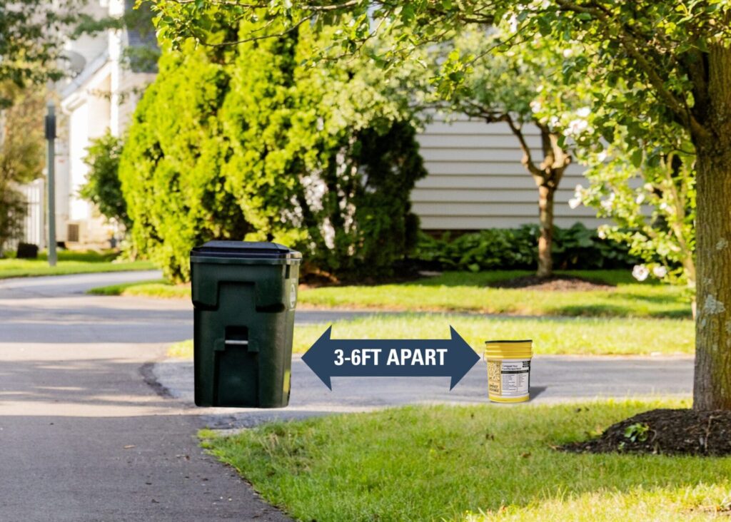 A large outdoor trash bin and a small yellow food scrap bucket placed on the ground with a double-headed arrow between them labeled "3-6FT APART" indicating recommended distance.