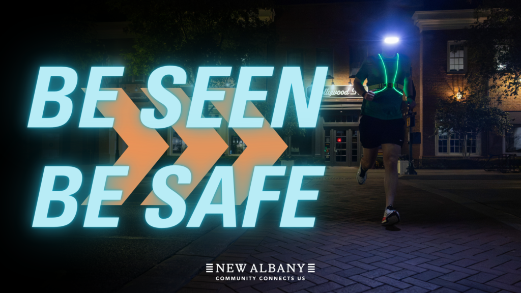 A runner in the dark wearing reflective material and lights. the words on the graphic read "Be Seen, Be Safe"