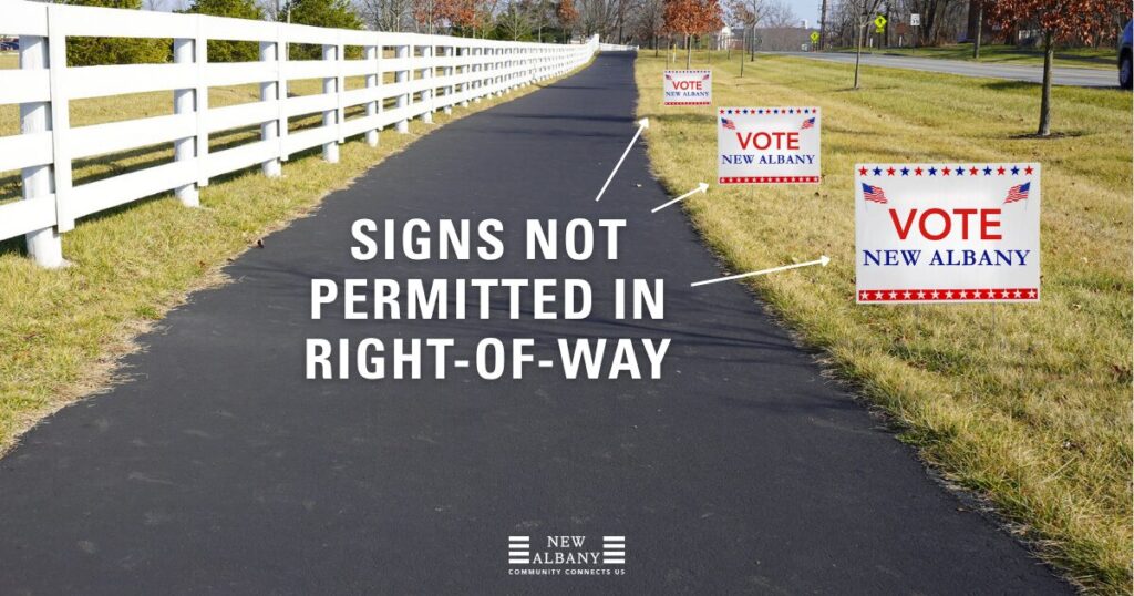 Paved pedestrian path with a white fence on the left and grassy right-of-way on the right showing multiple 'VOTE New Albany' yard signs in the grass and large overlaid text and arrows stating 'SIGNS NOT PERMITTED IN RIGHT-OF-WAY'.