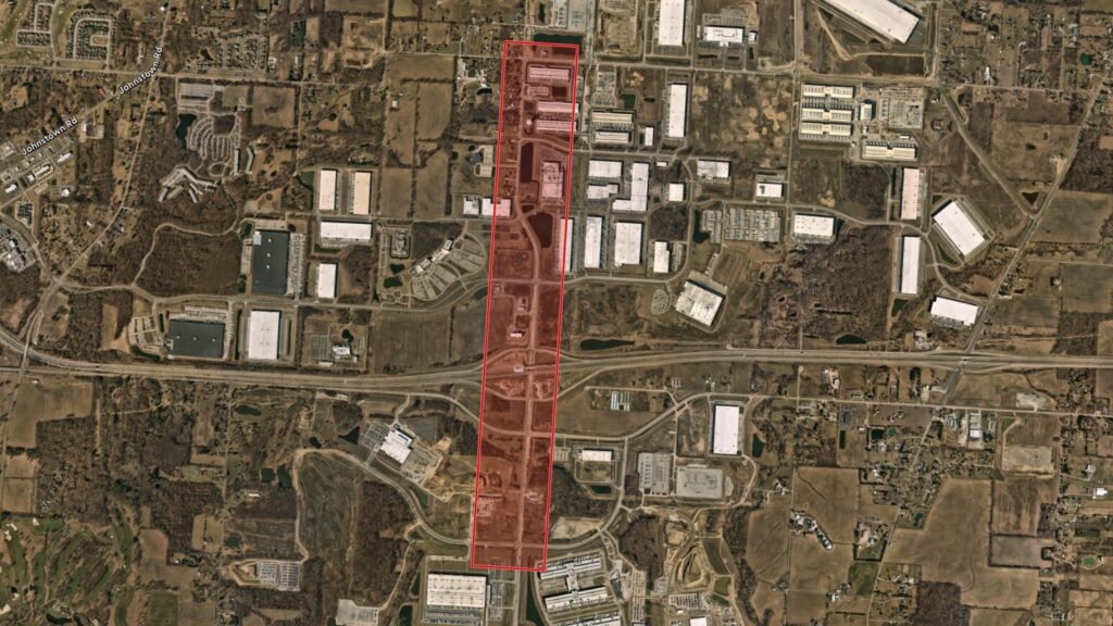 Aerial view of a highway corridor and surrounding warehouses, marked by a long red rectangular overlay.